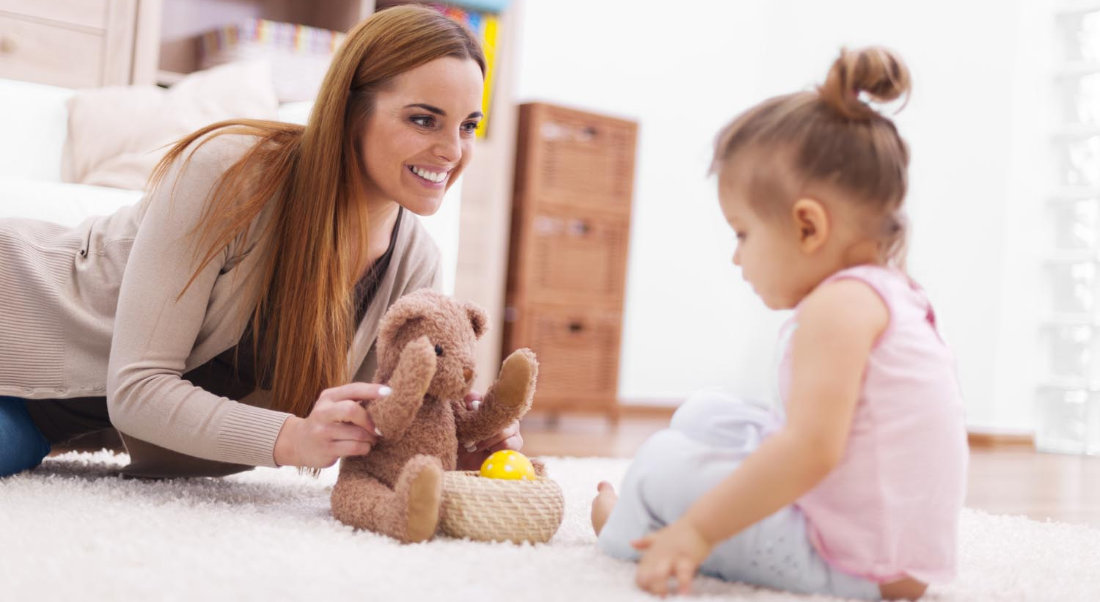 Mother playing with her baby on carpet The Clinic